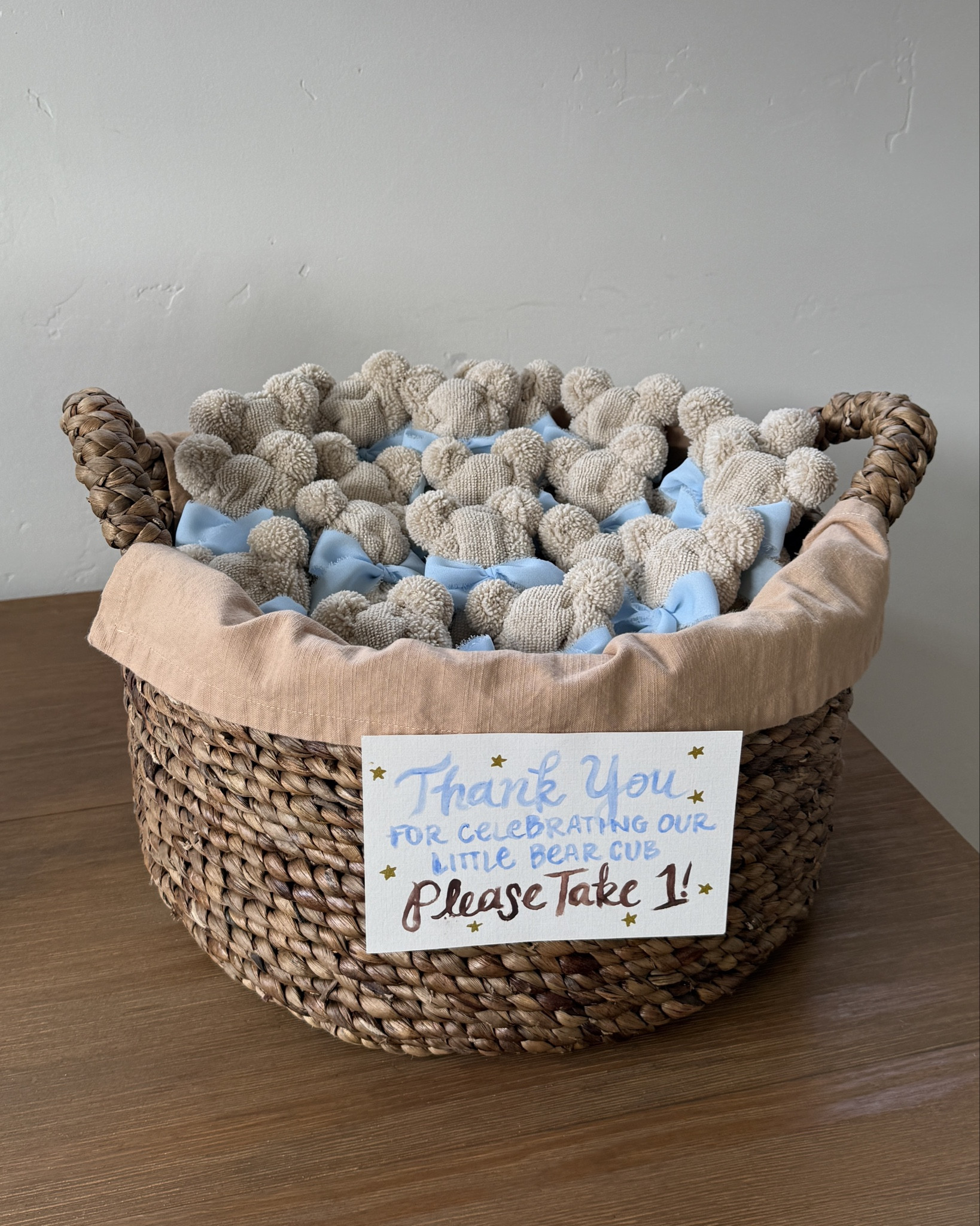 Cutest baby shower teddy bear favor DIY! 🧸 only using 3 things - square washcloths of any size, clear elastics and chiffon ribbon! Basket is from HomeGoods, and watercolor sign is had painted! Video on my page showing how to fold the washcloths into bears 🤍🍼

#LTKBump #LTKmomlife #LTKBaby