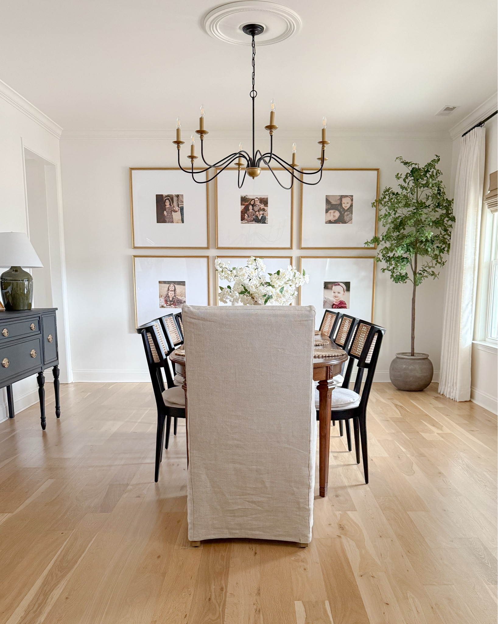 Modern Traditional Dining Room Inspo. Black cane dining chairs, upholstered slipcover end chairs, vintage oval dining table. Black vintage Hepplewhite style buffet. Oversized gold picture frames 

#LTKFindsUnder50 #LTKHome #LTKStyleTip