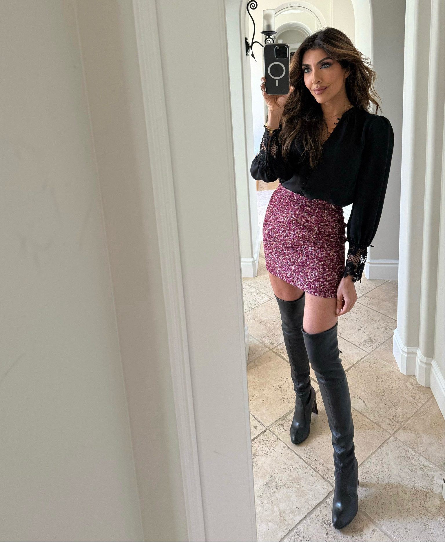This glittering mini is such a showstopper - but it's all about how we style it! When playing with proportions, having one bold focal point is key. The sleek black blouse with those delicate lace cuffs keeps things elevated, while these over-the-knee boots are absolutely genius - they make the shorter hemline feel so much more refined. It's the perfect balance of sparkle and sophistication.
