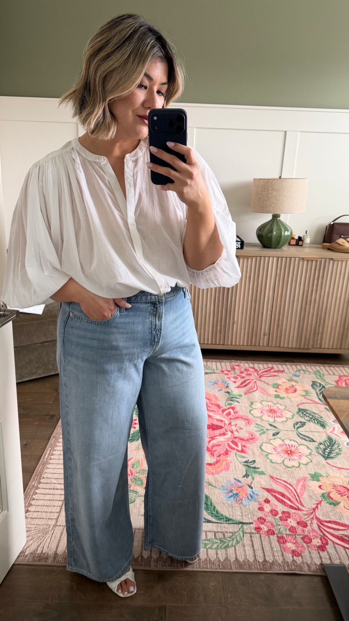 I first shared these jeans over this past weekend as I tried them on in the dressing room. I loved them in the dressing room and now that I am home I can confirm that I love them just as much as I did when I first tried them on. They are incredibly soft. The silhouette on them is perfect for my body shape. The length is also perfect where I can either wear a kitten heel or a flat sandal or flat Mary Jane’s with them. I’m wearing a size 32 and I feel like they run true to size. I’m 5‘5“ for a reference and typically wear between a 12 and 14 comfortably. 

As for this blouse, you must wear a nude bra underneath. It will warn you that you can still ever so slightly see the nude if the material is pulled tight to your skin. However, since the material is very loose and blousy, I do not personally feel that it is an issue. This shirt does require some styling after putting it on. I highly recommend that you pull up the sleeves like I did here, and you have to tuck the shirt into your pants. When wearing this top, I recommend styling it with a bottom that is not flowy as well. 

#LTKMidsize #LTKootd #LTKOver40