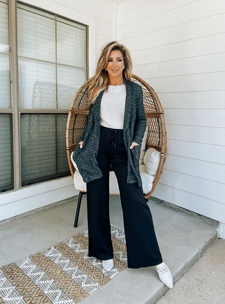 Dark grey knit cardigan with pockets, off white slouchy off the shoulder sweater knit top, black drawstring wide leg knit pants, business casual outfit, off whit mules slides

#LTKworkwear #LTKover40 #LTKstyletip