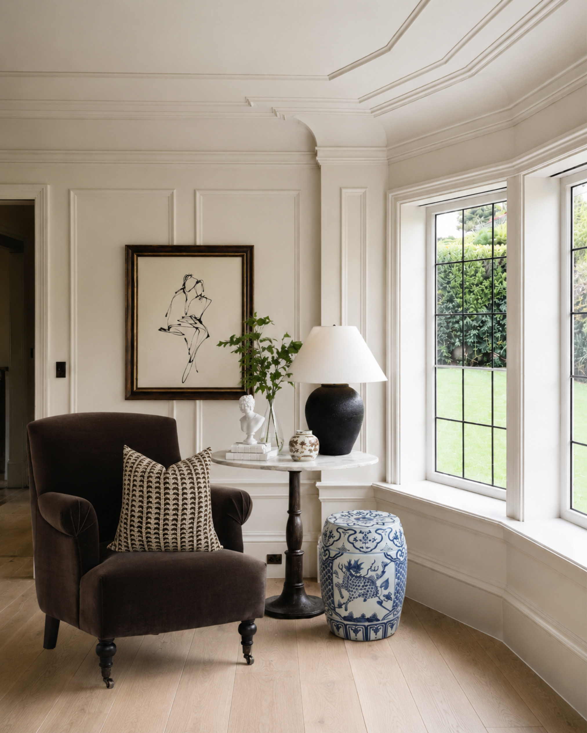 A classic accent chair moment with warm wood floors, tailored wall molding, a black table lamp, framed art, and a blue-and-white garden stool. This is such an easy way to make an empty corner feel intentional, layered, and expensive without overfilling the space.

I may receive a commission from purchases made through my links. 

 #LTKHome
