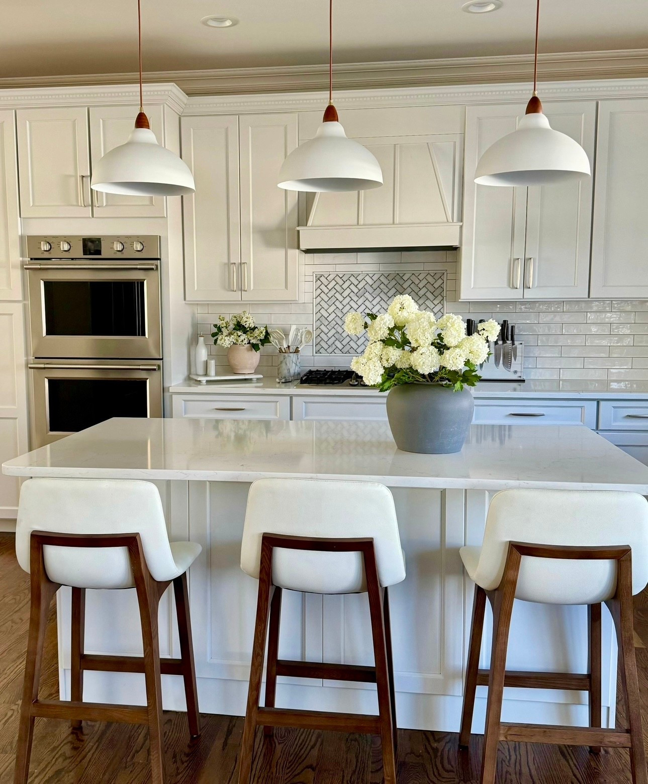 Soft white florals to warm up an all-white kitchen. Paired with wood barstools and clean pendant lighting for contrast.

#Kitchen
#Florals
#Barstools
#Lighting
#CounterStools


#LTKSeasonal #LTKHome #LTKSaleAlert