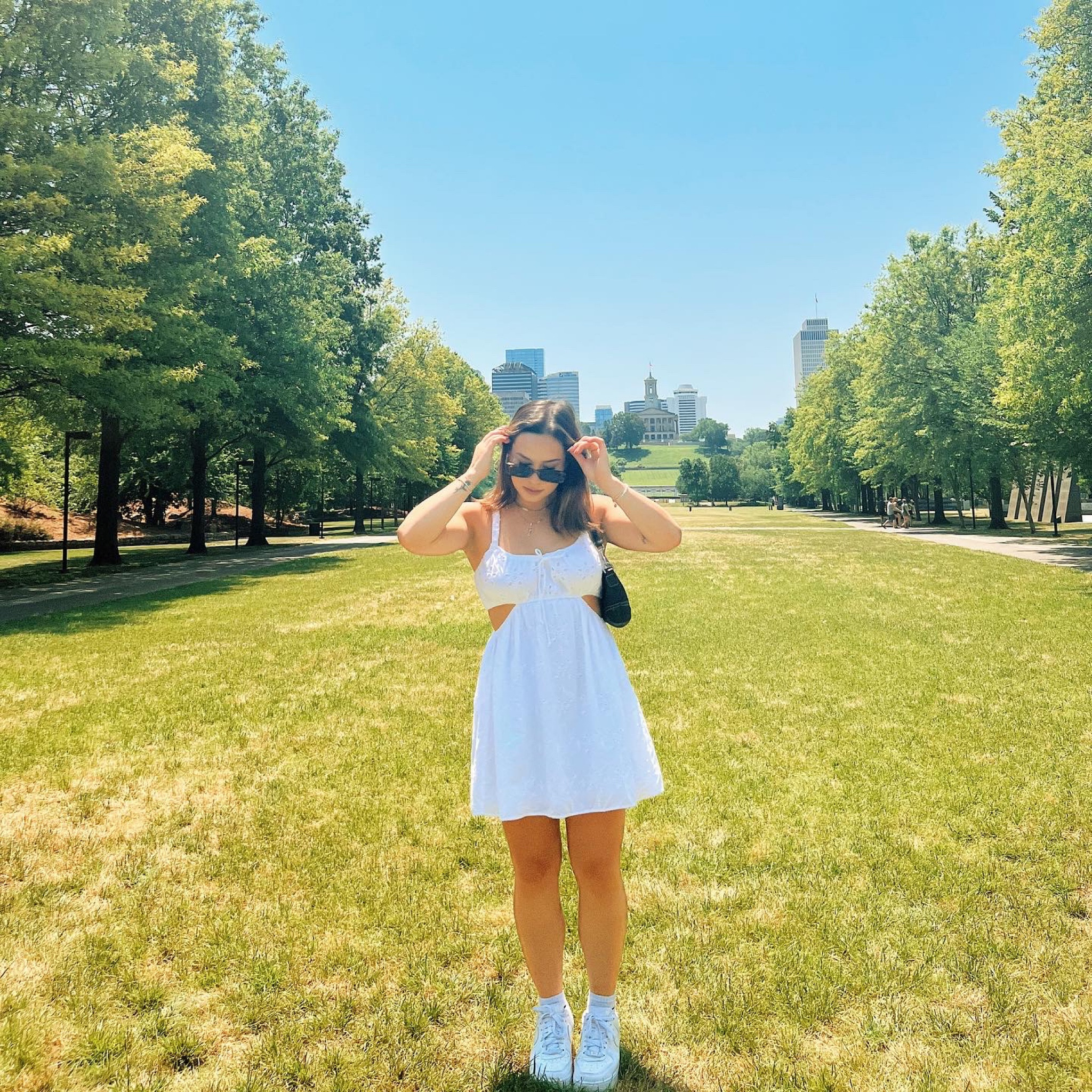 Casual summer dress for a day walking around Nashville. Wearing a white dress from American Eagle, with oak and fort square sunglasses and white air forces. 

#LTKtravel #LTKstyletip #LTKunder50
