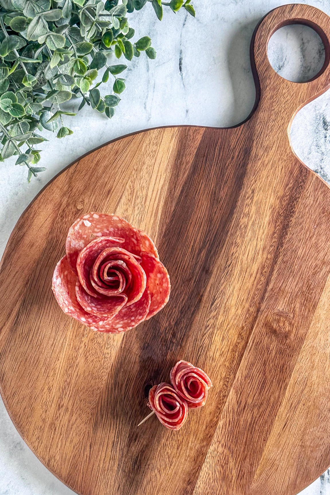 SALAMI ROSE - two ways ⬇️⬇️

Salami Roses
1. Tools: 2oz condiment cup and 11 salami slices
2. Layer: Place 5 slices halfway over the first one around the cup. 
3. Create the bud: Fold 6 slices of salami in half with the rounded side up. Layer the folded slices on top of the other right to left. 
4. Roll: Start rolling from one end to the other, securing the base as you go.
5. Finish: Gently spread the “petals” to create a rose shape.

Salami Rosettes ⬇️
1. Stack: Lay out a few slices of salami in a straight line, slightly overlapping each other.
2. Roll: Roll the entire line of salami slices into a tight spiral.
3. Secure: Use a toothpick to hold the rosette together. 

PRO TIP: Mix and match different types of salami for added texture and flavor. 🌟

SAVE and FOLLOW @charcuterie_n_things for more cheese and charcuterie food styling tips!

#charcuterieandthings #foodstyling #cheese #charcuterieboard #salamirose #easyrecipes