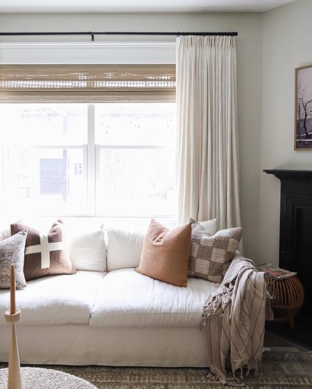 Budget-friendly pinch pleat drapes, custom woven blinds, white sofa, checkered pillow 

#LTKhome