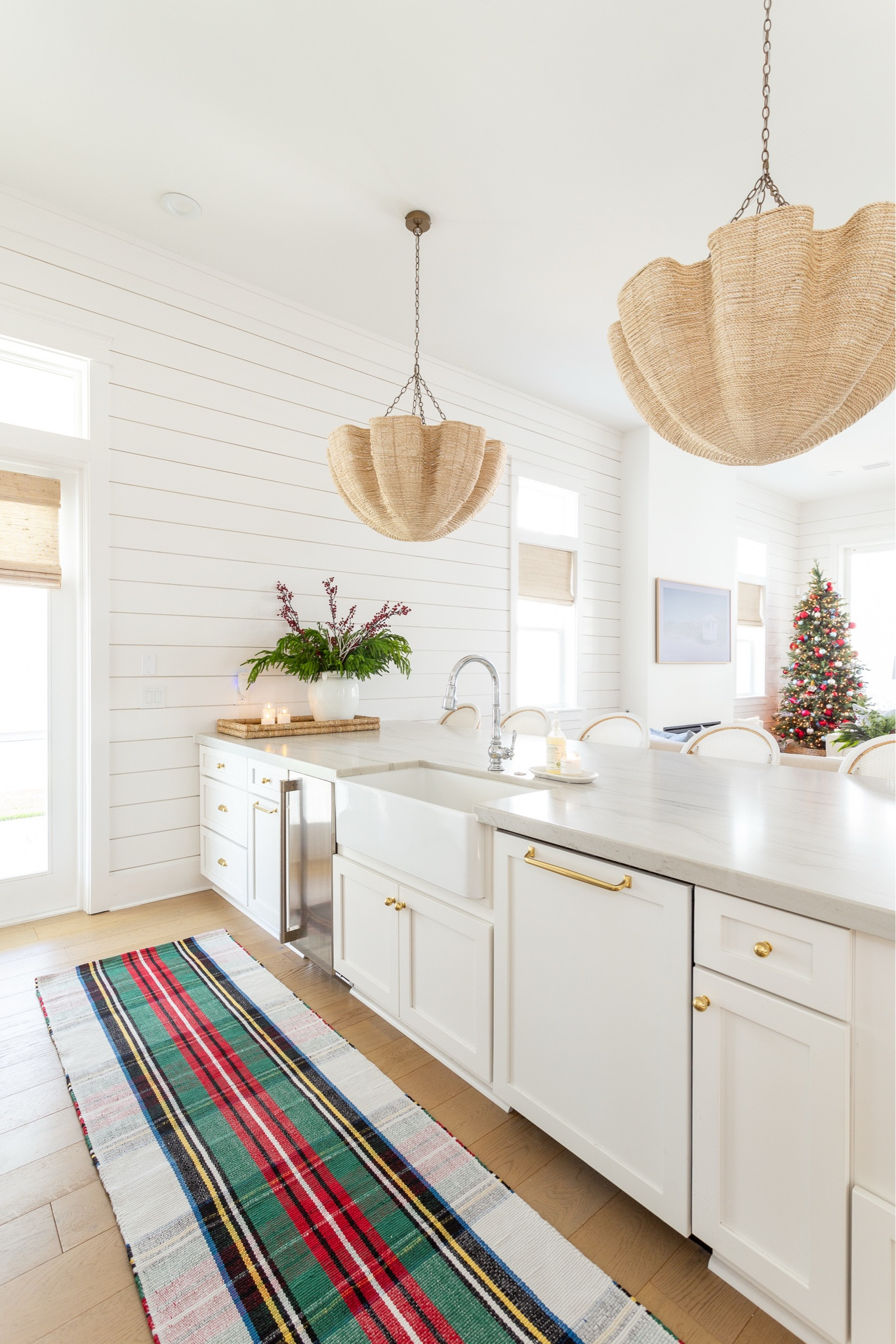 Our coastal kitchen with white cabinets and white oak floors, decorated for Christmas with a tartan plaid rug, real-touch wreath, Christmas bows, flameless candles pillars, scalloped woven chandeliers, and Christmas hand soap. #ltkhome #ltkholiday #ltkseasonal #ltkfindsunder50 #ltkfindsunder100 #ltkstyletip #ltksalealert 

#LTKSeasonal #LTKHome #LTKHoliday