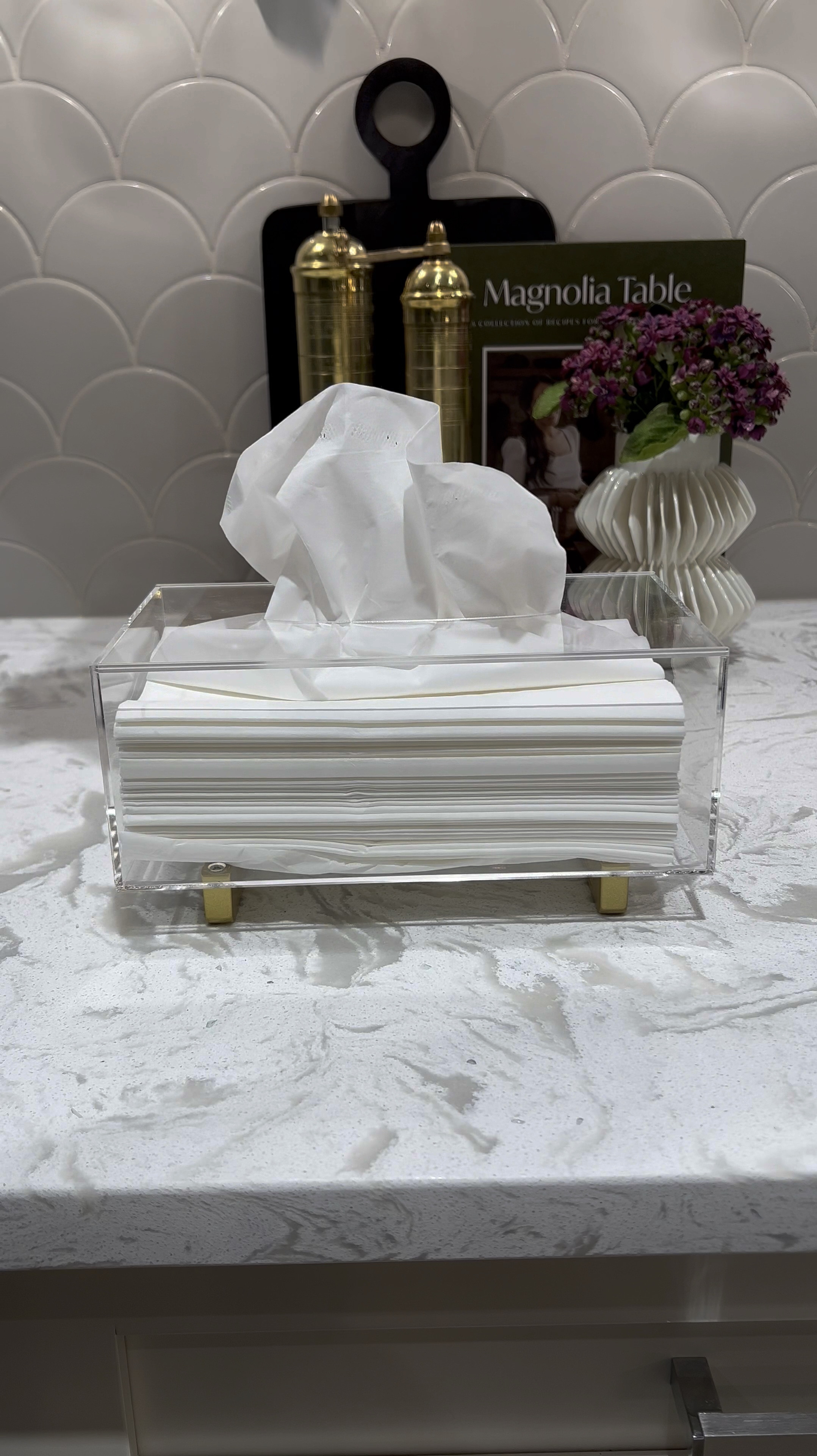 I love this acrylic tissue paper holder. It adds an elegant touch to any space. Style it on your bathroom or on any side table! 💕

Kleenex holder 
Tissue holder 
Salt and pepper mill 
Wooden pedestal tray
Small white vase
Countertop styling 