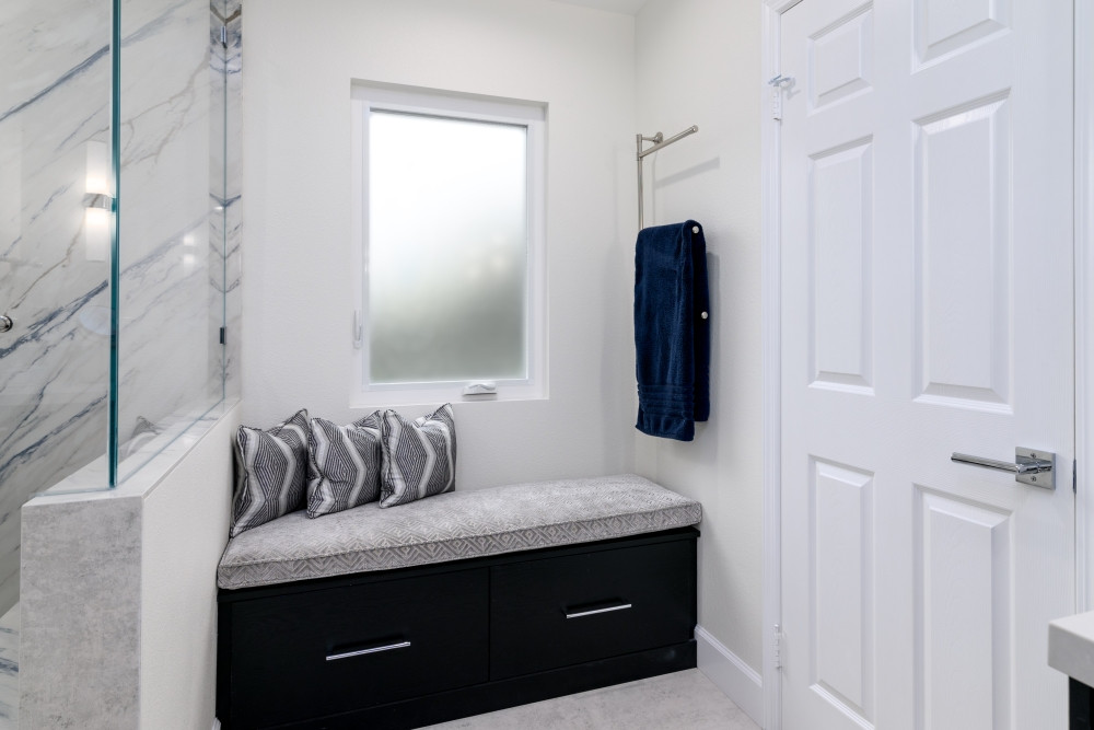 A custom black bench with storage drawers adds both function and style to this bathroom remodel! Topped with a light gray cushion and pillows that match the shower wall material, this cozy seating nook blends seamlessly with the space. Who else loves a built-in bench moment?

#BathroomDesign #BathroomRemodel #CustomStorage #InteriorDesign #ModernBathroom #LuxuryBathroom #BuiltInBench #FunctionalDesign #BlackBench #CustomCabinetry #ShowerDesign #BathroomSeating #DesignDetails #TimelessInteriors #HomeRenovation #LTKinteriors #DreamBathroom #StorageSolutions #StatementSeating #HomeInspo 

 #LTKHome