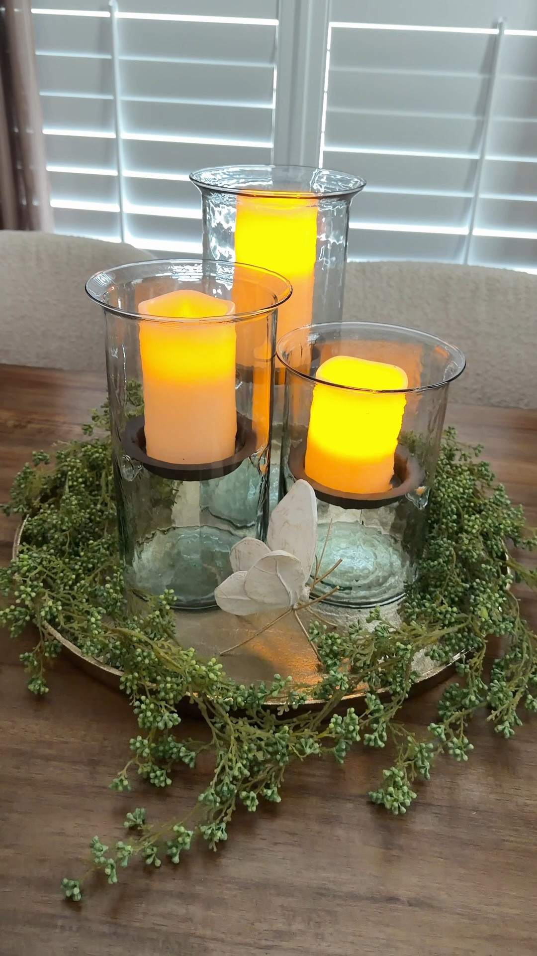 This is one of those setups that doesn’t try too hard, but still pulls you in. That soft glow alone makes the whole space feel different. I could move this from a coffee table to a kitchen corner and it would still work just as well.

The hurricanes are a standout on their own, but I keep thinking how pretty they’d be with petals tucked in the bottom—just something subtle. I added a couple of draping berry stems and stopped right there.

Nothing forced, nothing overstyled… just pieces working together the way they’re supposed to  