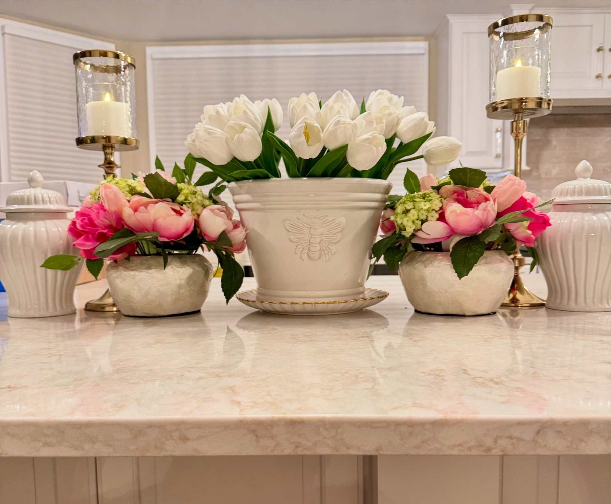 A blooming moment of elegance—white tulips take center stage in a charming bee-embossed pot, flanked by lush pink peonies and glowing candlelight. A sweet spring symphony on marble.

#SpringDecor #FloralInspo #KitchenStyle #FreshBlooms #PeonyLove #TulipSeason #ElegantInteriors #HomeVibes #TablescapeGoals #BeeInspired #CandlelightGlow #ChicHomeDecor #FeminineTouches #NeutralPalette #FlowerArrangement #MarbleCountertop #TimelessDesign #BloomingBeauty #InteriorDetails #FloralFantasy

#LTKHome #LTKSeasonal