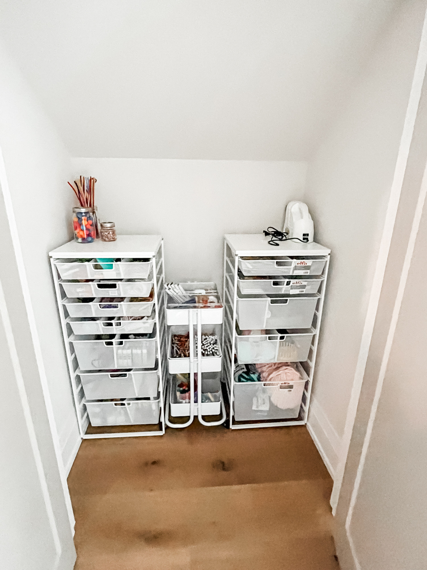 Ready, set, craft! These Elfa drawer units and the three-tiered cart couldn't fit this space better if they were custom-made. As always, these are some of our favorite products to use for organizing things like craft supplies. This space is ready for crafting... and then ready to be tidied up in an organized manner because we've created a framework to keep everything in its place! 

 