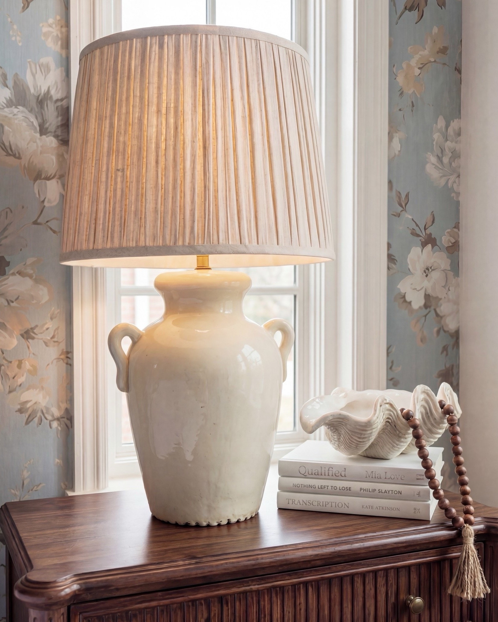 Bedroom Refresh : Shop The Look.
This bedroom is giving soft serenity with a touch of old-world charm. The blue floral wallpaper instantly sets a calming tone, bringing in that fresh, airy feeling while still feeling warm and romantic. The dark wood bed adds richness and depth, and the brass accents give it that quiet luxury moment.

The chunky knit throw brings all the coziness, and the bouclé stools at the foot of the bed add just the right amount of texture. And can we talk about the ceiling? Those exposed beams make the entire room feel architectural, grounded, and so intentional.

The window seat is the sweetest finishing touch — layered pillows, soft drapery, and the perfect nook for slow mornings. Every detail feels thoughtful, calm, and beautifully timeless.

Shop the Look:
• Blue floral wallpaper
• Dark wood bed with brass accents
• Cream bouclé round stools
• Chunky knit camel throw
• Neutral patterned area rug
• Light wood + ceramic table lamps
• Brass round wall mirror
• Window seat pillows in warm neutrals

#LTKhome #LTKsale #LTKstyletip