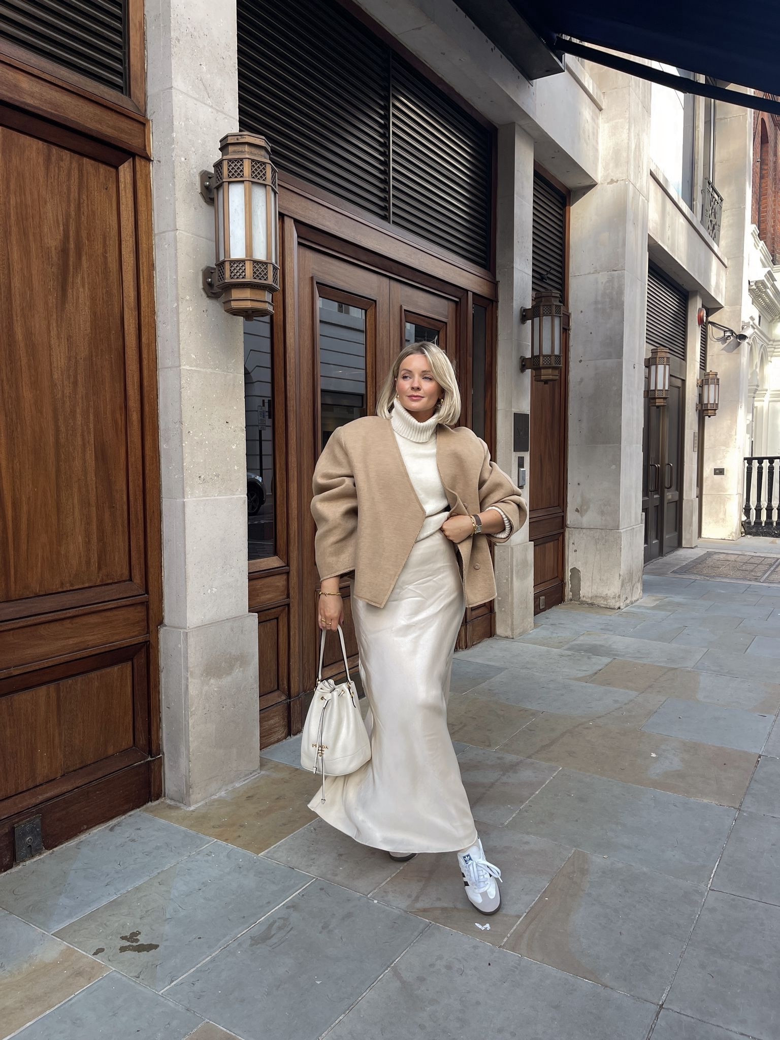 Autumn cream & brown beige outfit for shopping in London - arket cream satin maxi skirt, cream roll neck knit jumper, adidas samba trainers, Prada cream bucket bag & H&M light brown short wool blend jacket. 

#LTKSeasonal #LTKeurope #LTKstyletip