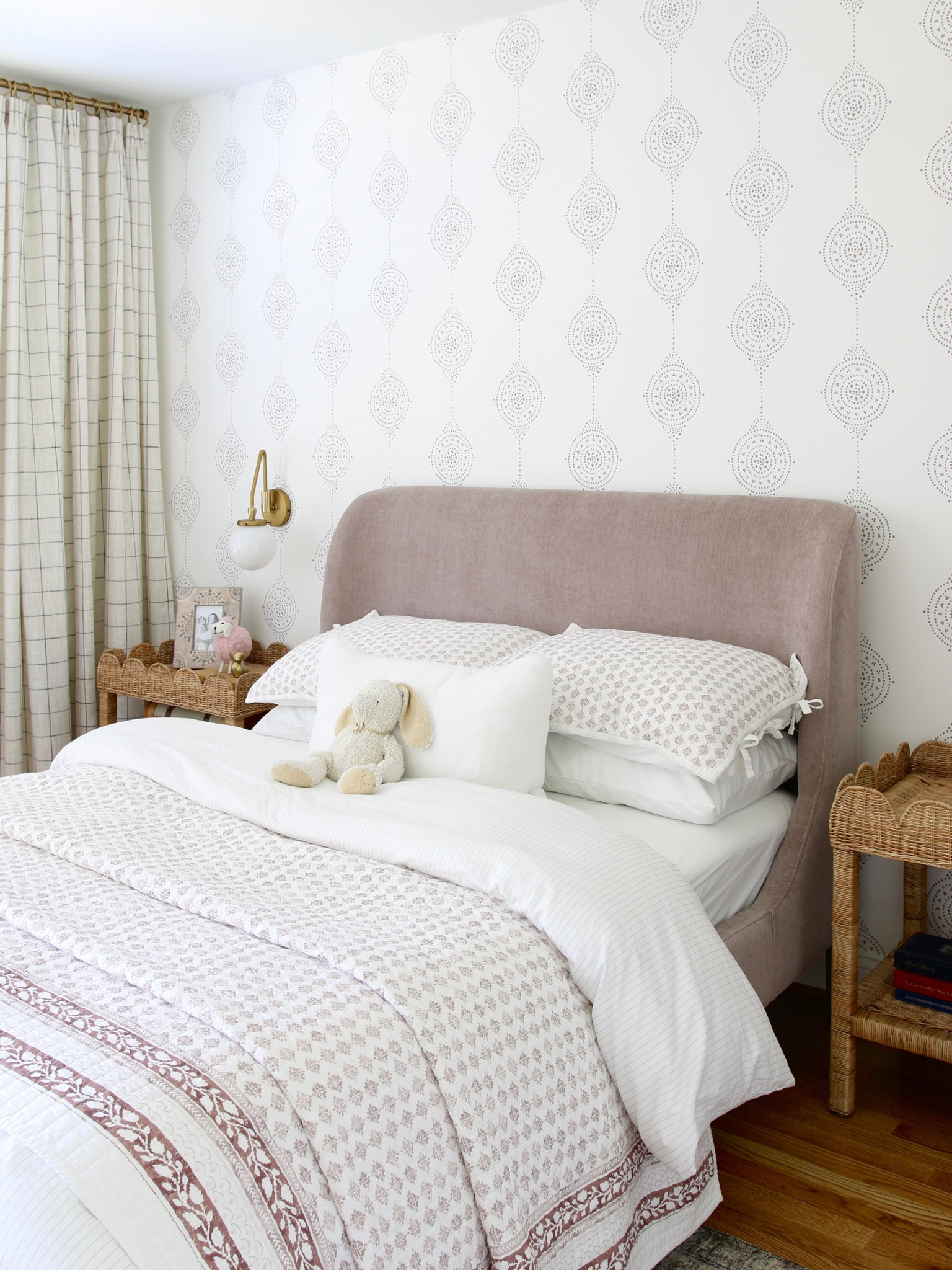 This is my updated girl’s room. I used a wingback upholstered bed. The bedding includes cotton slub wood block print quilt and sham. 
I used Luna Stripe wallpaper from Serena and Lily, a wood beaded pendant and Loloi Margot rug. The nightstands are wicker scalloped side tables 

#LTKstyletip #LTKFind #LTKhome