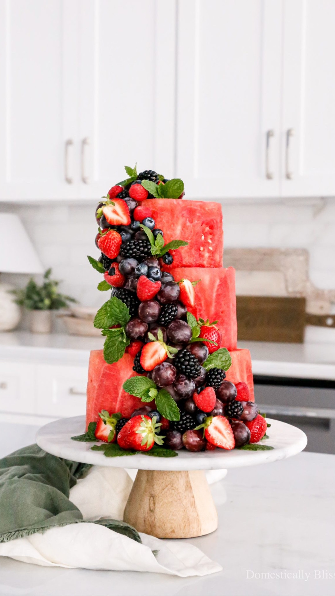 This viral Watermelon Cake is one of my favorite summer fruit DIYs.
With over 120 million views and 2.6 million likes, I’m guessing it’s one of your favorites too!
It’s made entirely of fruit and finished with extra fruit and fresh mint leaves.
I secured the watermelon layers with long wooden skewers and attached the hanging fruit using wooden toothpicks.
We took it to a large family gathering that night with Roger’s family, for 30+ people to enjoy.
And serving was as easy as slicing and enjoying.
Don’t worry! We weren’t responsible for dessert!
This was just a fun alternative to a fruit platter (and I brought a traditional dessert, too).
Here are some answers to a few recurring questions I’ve received:
Serving:
Cutting and serving is simple, just like with a regular cake.
When it was time to eat, I immediately cut into the watermelon cake so no one hesitated to be the first.
You can remove the toothpicks from the fruit before serving or leave them in for easy finger food.
Cleanliness:
For anyone concerned about hygiene, I’m diligent about washing my hands. I don’t sell my creations; I share them only with family and close friends.
When to Make:
I made this Watermelon Cake in the late morning/early afternoon and served it in the evening. More details about refrigeration and transportation are on my blog.
Are you planning to make a Watermelon Cake this summer?
P.S. My (then) 2-year-old son and 92-year-old grandmother both loved snacking on the extra watermelon while I made this summer cake.

See details: https://domesticallyblissful.com/watermelon-cake/





#LTKfoodie #LTKSeasonal