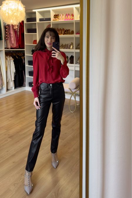 For a chic and alluring fall night out, put on a stylish fit that effortlessly combines elegance with a touch of edginess. The &OtherStories frilled red silk blouse is giving, capturing attention with its vibrant hue and delicate frill details. Paired with sleek black faux leather pants, this outfit strikes a balance between sophistication and modern flair.
The combination of the frilly red silk blouse and the sleek leather pants creates a captivating juxtaposition, making it an ideal choice for various fall occasions. Whether you're planning a date night, a casual dinner with friends, or a night out at a trendy bar, this outfit exudes confidence and style. Pov you can even wear it for work. To elevate the outfit further, slip into a pair of Valentino Garavani Rockstud kitten heel pumps. The iconic Rockstud detailing adds a luxurious touch to the outfit while ensuring comfort all day long. The patent leather of the pumps complements the leather pants and adds a polished finish to the overall look. This fall-inspired outfit not only embraces the seasonal color palette, it a versatile choice for various fall occasions. The outfit effortlessly transitions from the desk to the table - either for a casual dinner setting or a more upscale bar or evening event. Whether you're heading for a casual dinner or a trendy bar, this outfit effortlessly combines romance, edge, and sophistication, making you the epitome of style for the autumn season. #leatherpants #falloutfit #dateoutfit #workoutfit #silkblouse 

#LTKHoliday #LTKworkwear #LTKSeasonal