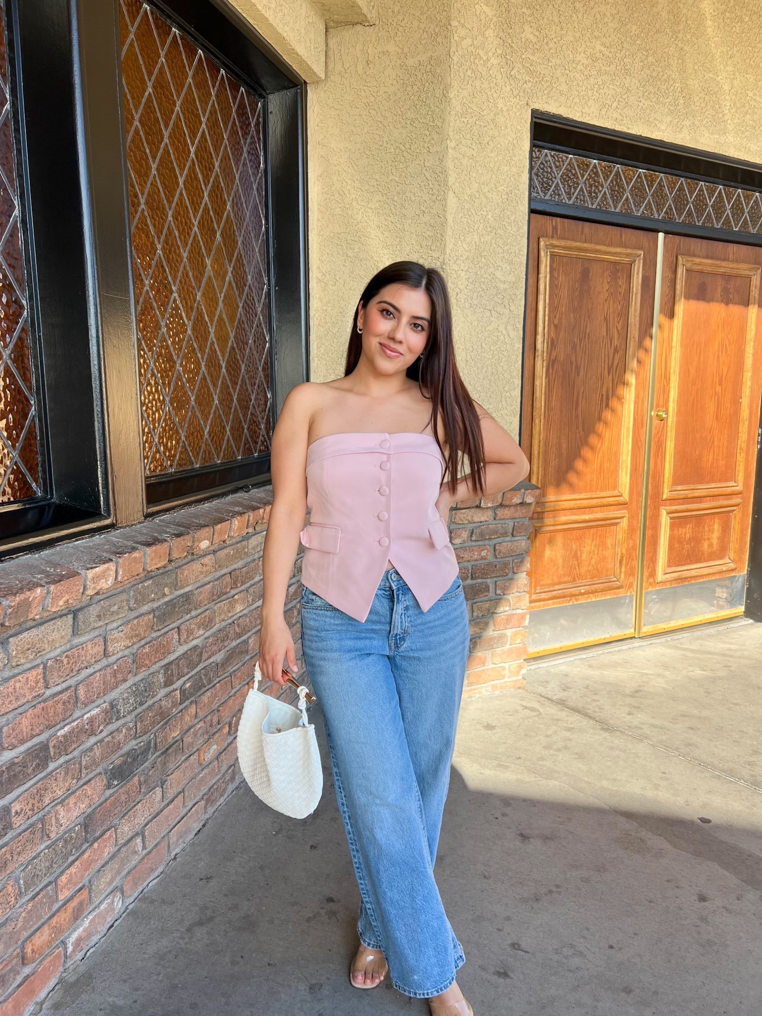 This spring-ready look is giving major chic vibes with a strapless blush pink button-up top styled perfectly with high-waisted straight leg jeans. Finished the outfit with clear nude sandals and a textured white mini bag, making it a polished yet casual daytime look. Ideal for brunch or weekend outings, this outfit nails the feminine casual aesthetic with neutral accessories and effortless styling.

#LTKTravel #LTKSeasonal