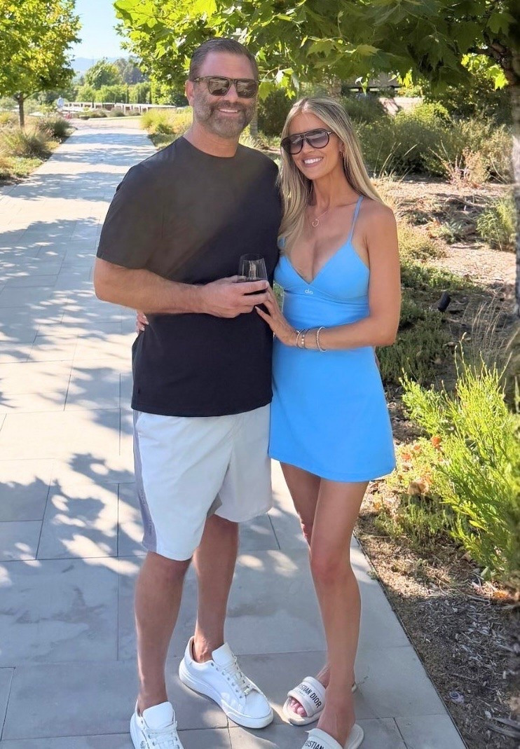 Christina Haack via Instagram on July 25, 2026. Christina wears azure blue dress, white slides , yellow gold diamonds Juste un Cleu necklace and white gold bracelets by Cartier and black sunglasses