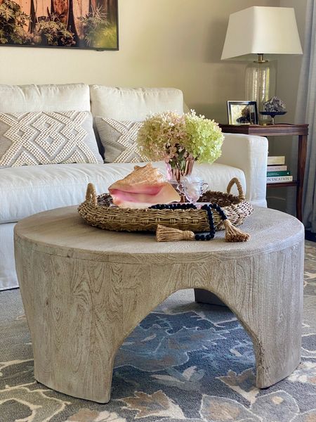 A coffee table is the perfect place to express your style. I accessorized this round coffee table with a tray, a sea shell, wood bead garland, a vintage candy dish with mints, and fresh cut hydrangeas in a vintage vase from one of my mom’s dear friends all stacked on a coffee table book. 
kimbentley, living room, coffee table 

#LTKSeasonal #LTKhome #LTKstyletip