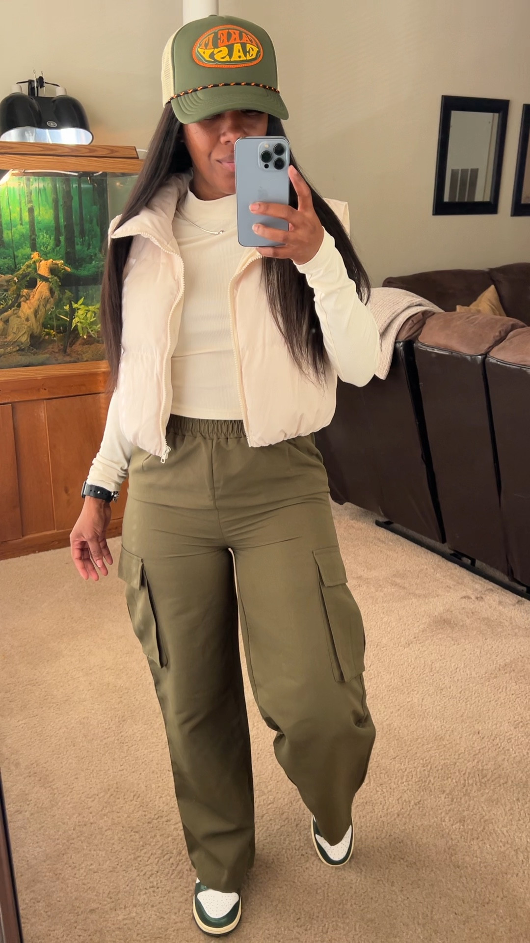 Olive green outfit idea, spring outfits, cargo pants, puffer vest.
I’m wearing a beige cropped long sleeve shirt, olive green cargo pants, beige puffer vest, and a green take it easy trucker hat.