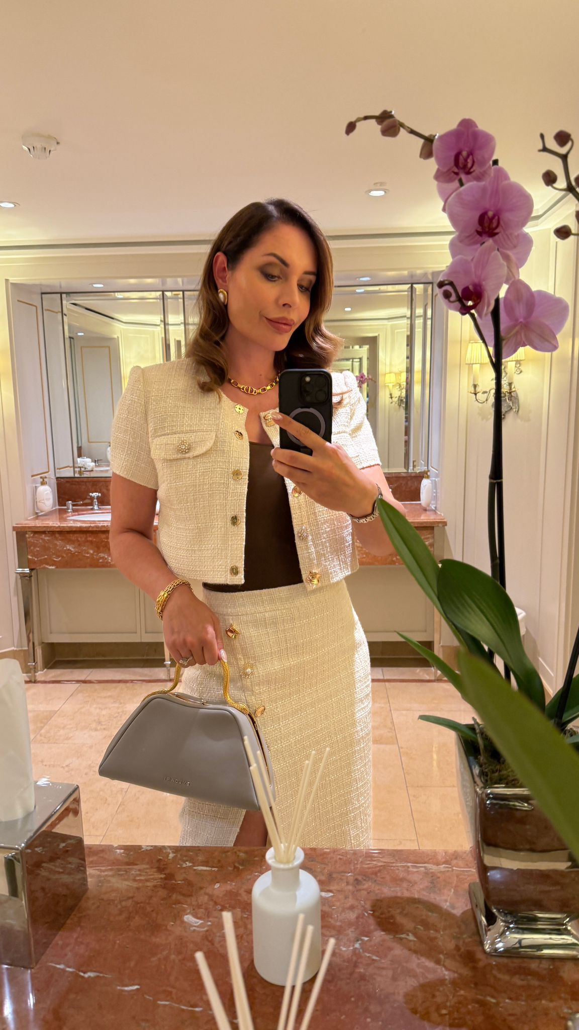 A new favourite mix of textures 🤍 I paired this Self-Portrait tweed slit skirt with a sleek brown Skims bodysuit and a cropped white jacket that gives off that sharp, blazer-inspired look. Paris Texas boots in white complete the monochrome base, while gold jewelry and my Bulgari Serpentine top handle bag add the final polish. ✨

I’ve also linked some other tops I absolutely love that work beautifully with this look, along with a shorter skirt option if you want a more playful version. 

 #LTKSeasonal #LTKParties #LTKStyleTip