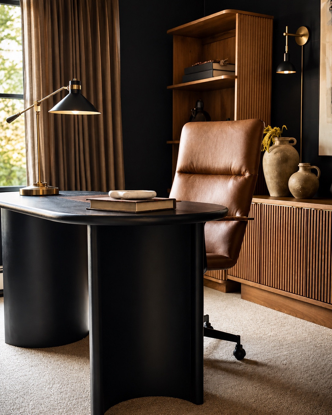 The client asked for a moody office… but creating this look did not require expensive custom built-ins! 
One of my favorite design tricks is using ready-made bookcases and cabinetry to create that elevated, custom feel without the custom price tag. By layering rich tones, warm wood textures, dramatic contrast, and thoughtfully styled pieces, this office completely transformed into a space that feels sophisticated, cozy, and intentionally designed.
Proof that you do not always need fully custom millwork to create a high-end look 🤎 

@westelm @TWOPAGES