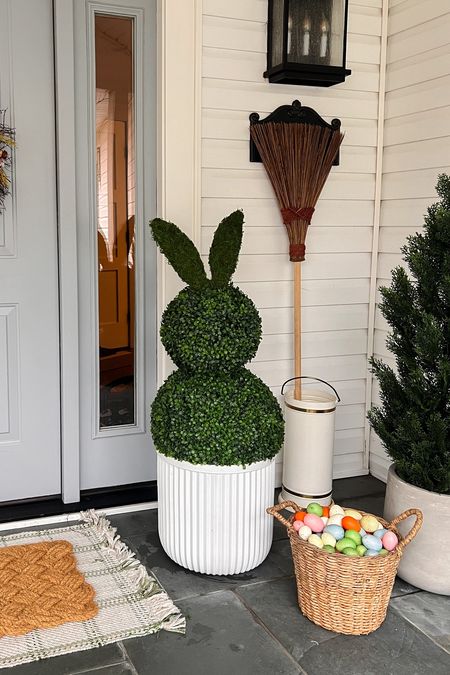 DIY Giant Topiary Bunnies

. **Materials You Need**:
   - Two faux boxwood balls
   - Zip ties
   - Self-sticking moss
   - Cardboard for ears
   - Scissors

   1) Take the two faux boxwood balls secure them together with zip ties 
  2) Cut out large bunny ear shapes from the cardboard.
   3) Cover the cardboard ears with self-sticking moss to match the boxwood. I hot glue popsicle sticks to the bottom of the ears so they would stand upright. 
   4) Attach the mossy ears to the top of your boxwood balls.

Since the ears are made of cardboard these will do best under a covered porch. 

#LTKhome #LTKSeasonal