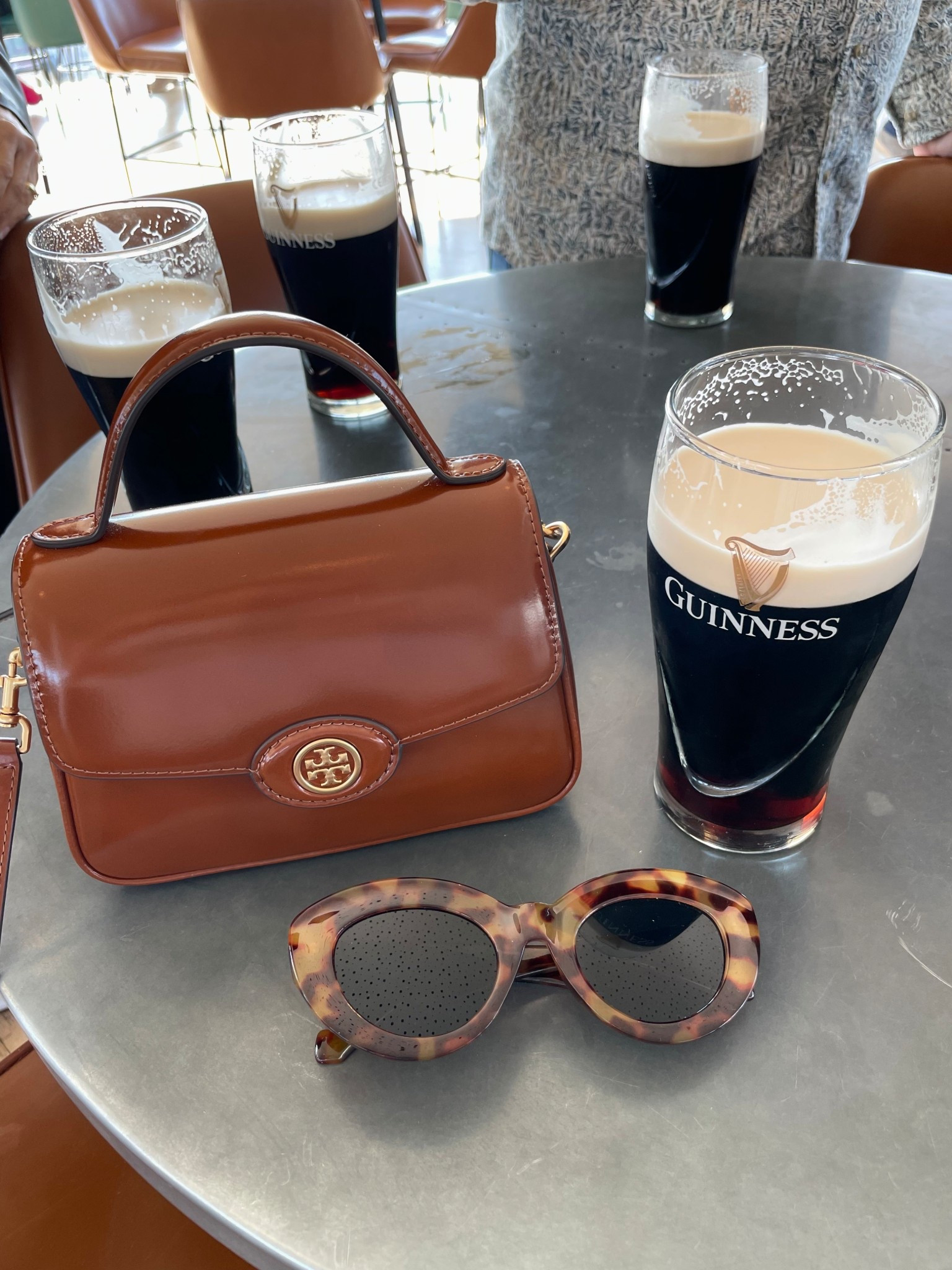 Accessories for the United Kingdom and Ireland. A pair of neutral tortoiseshell sunglasses and cognac crossbody purse from Tory Burch  

#LTKItBag #LTKTravel