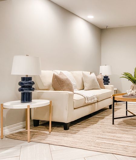 Using a neutral sofa and airy tables keeps spaces bright when you don’t have natural light from windows. 
.
.
.
Light & Bright
Basement Design
Neutral Sofa
Natural Wood
Navy Blue Lamp
White
Cream
Jute Rug

#LTKhome #LTKstyletip #LTKbeauty