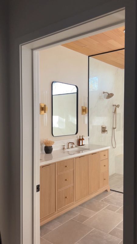 Bathroom remodel! Sconces, brass sconce, free standing tub, mirror, black mirror, wood vanity, brass faucet