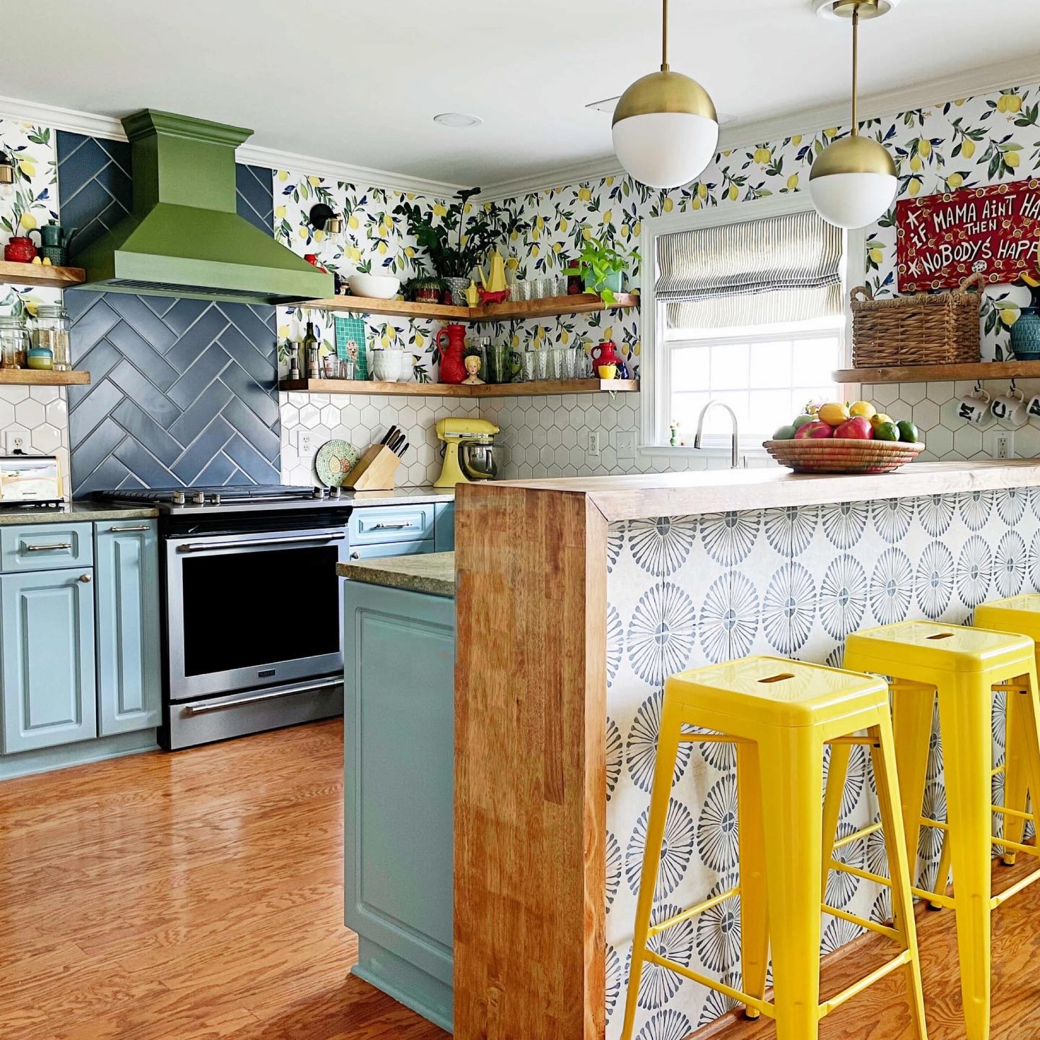 Kitchen, wood hood, lemon wallpaper, yellow stools, champagne bronze cabinet pulls, globe pendant lights, gas range, blue tile

#LTKhome