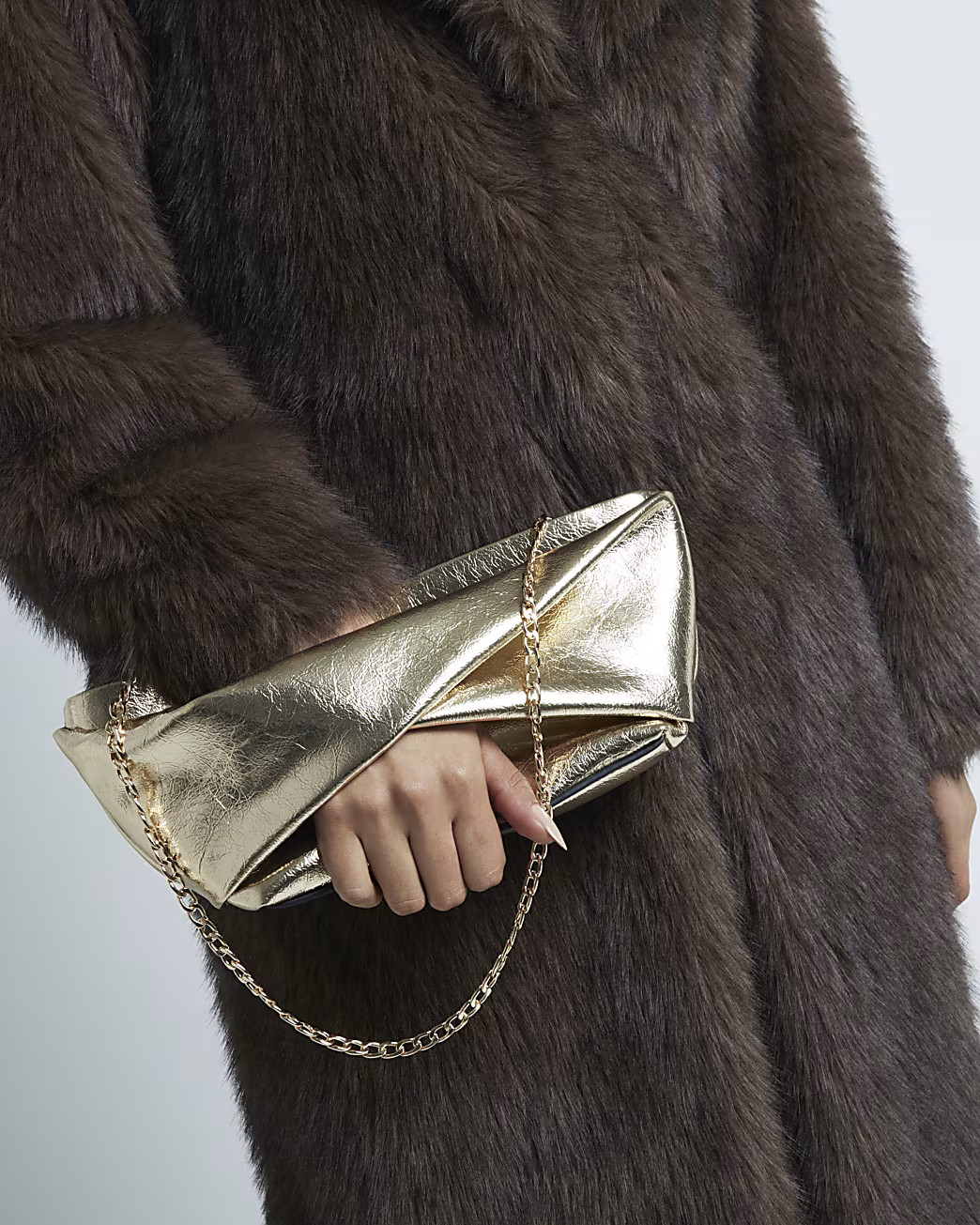 Gold Patent Twist Front Clutch Bag | River Island UK & IE