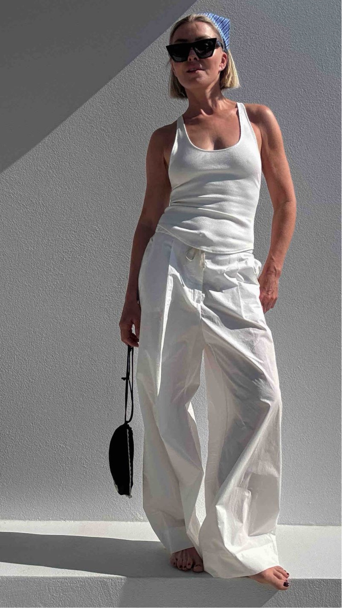 White poplin pants by SOEUR, wearing size 38. Tank by HENNE. Celine Disc & Edge sunglasses. Magda Butrym silk pouch.