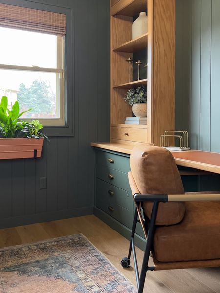 Cozy home office. Green built ins. Wood accents. Large faux leather office chair. Desk cover. Window box with greenery. Brass hardware. Brass drawer cup pulls and cabinet knobs. 

#LTKhome