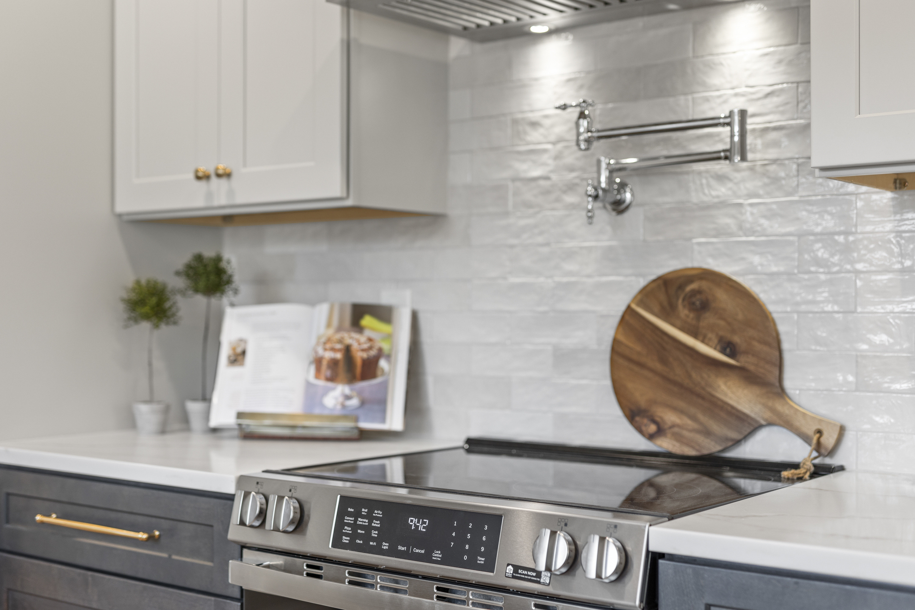 Kitchen Details! Tile backsplash, chrome pot filler, wood and brass cookbook stand