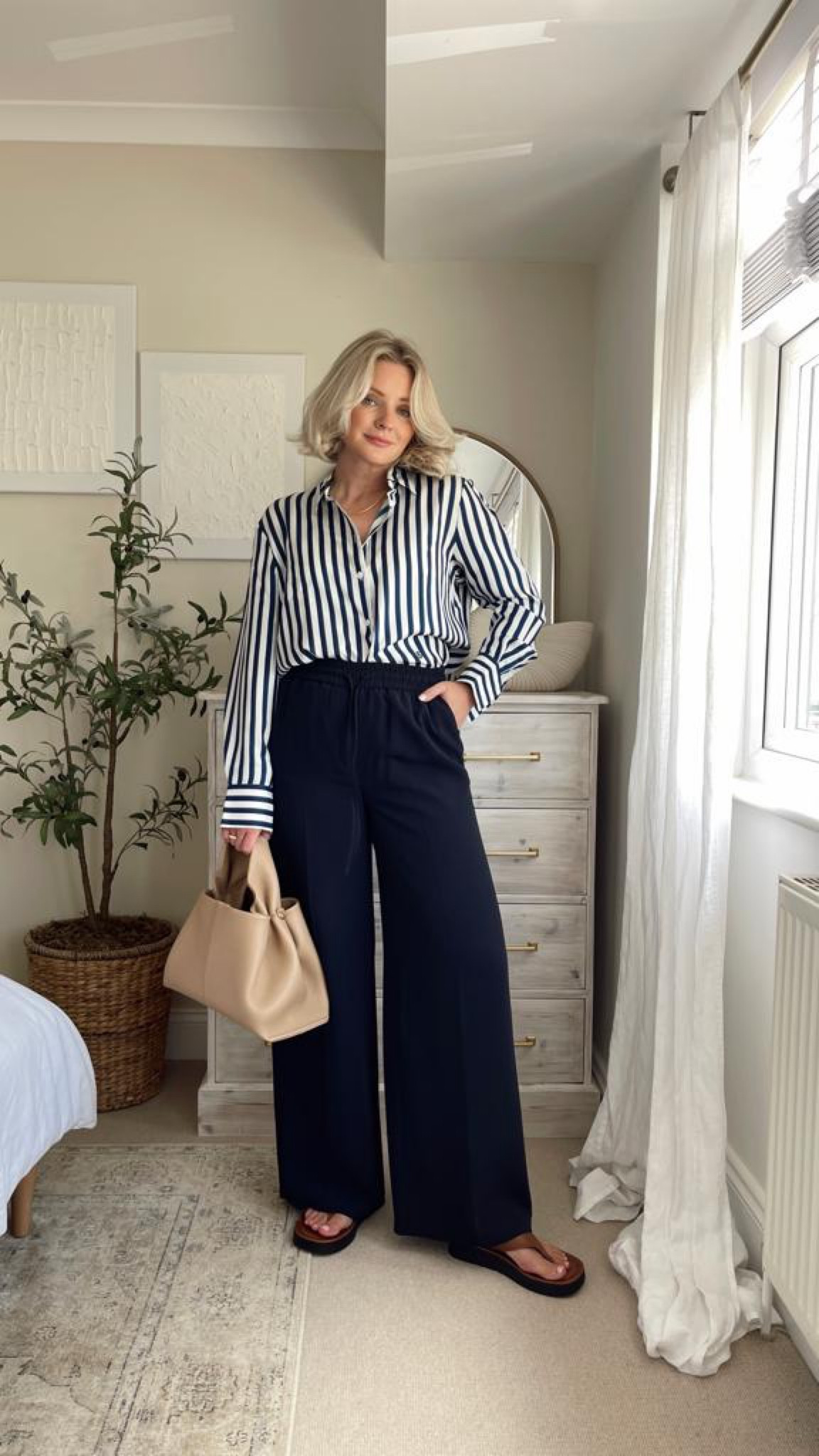 Ways to wear M&S navy trousers - Lily silk blue & white striped silk shirt, Polene Paris numéro neuf beige bag, tan flip flops  

#LTKstyletip #LTKeurope #LTKSeasonal