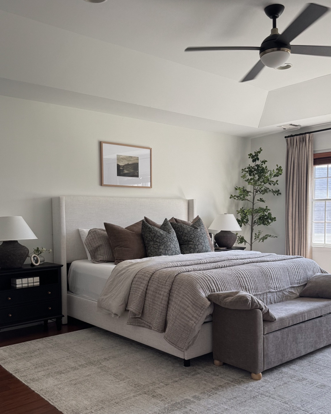 Primary bedroom, upholstered bed, bed bench, storage bench, bedroom rug, charging nightstands, nightstand decor, nightstand table lamp, Art above bed, olive tree, Amazon curtains

#LTKHome