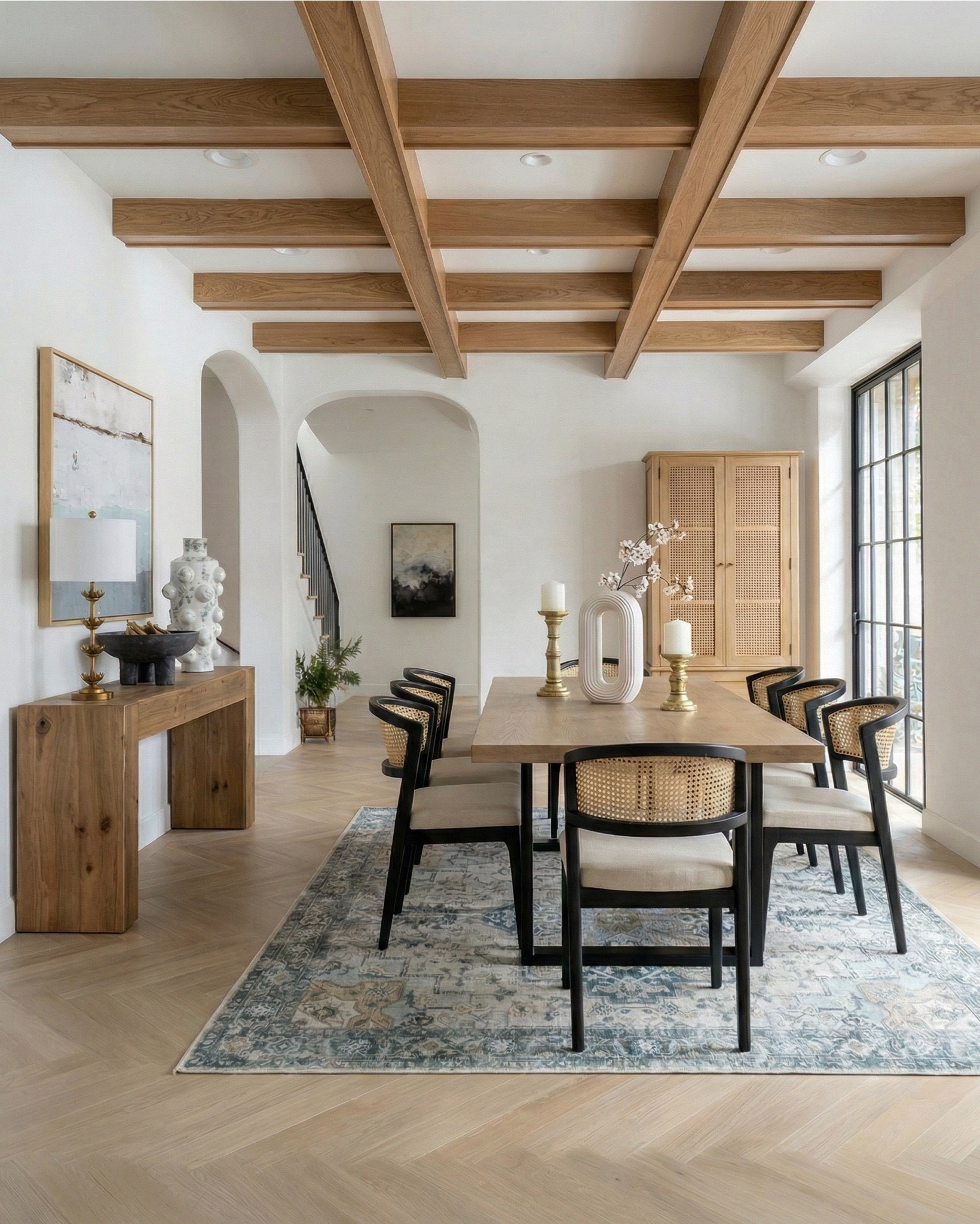 Shop the look: 
* Wood Dining Table
* Black upholstered dining  Chairs 
* Wood console table
* Brass table lamp 
* White ceramic vase
* Brass candle holders
* Blue wall art
* Neutral modern wall art
* Brass wall sconce 
* Wood cabinets 
* Blue traditional pattern rug
* Blue wall paper
* Tall ceramic vase
* Black decor bowl

#LTKhome #LTKsale #LTKstyletip