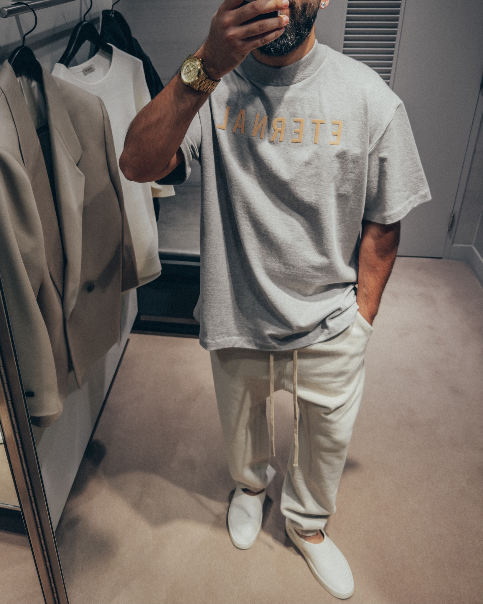 SALE 🚨 25% OFF on Saks Fifth Ave currently on full look. 20% OFF full look on Mr. Porter applied at checkout… FEAR OF GOD Eternal Collection T-Shirt in ‘Grey’ (size M), Classic Sweatpants in ‘Cement’ (size M), and California slides in ‘Greige’ (size 41). A relaxed and elevated men’s look that’s cozy and chill for a Spring day out. Layer with hoodie and bomber jacket for added warmth. 
