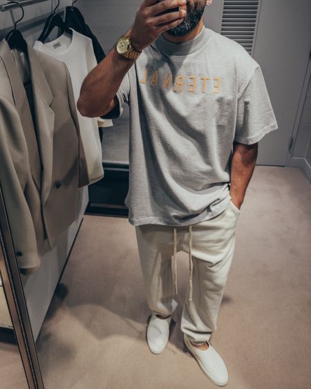 SALE 🚨 25% OFF on Saks Fifth Ave currently on full look. 20% OFF full look on Mr. Porter applied at checkout… FEAR OF GOD Eternal Collection T-Shirt in ‘Grey’ (size M), Classic Sweatpants in ‘Cement’ (size M), and California slides in ‘Greige’ (size 41). A relaxed and elevated men’s look that’s cozy and chill for a Spring day out. Layer with hoodie and bomber jacket for added warmth. 