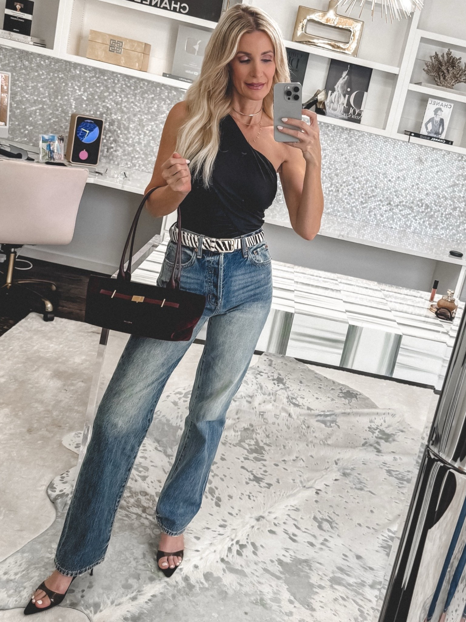 An easy way to elevate your favorite jeans for date night! This chic black one-shoulder bodysuit and zebra-print belt make the entire look feel modern and stylish. I’m wearing an XS in the bodysuit and belt and a 24 in the jeans. #DateNightStyle #BlackBodysuit #StatementBelt #DenimOutfit #WomenOver40Style 

 