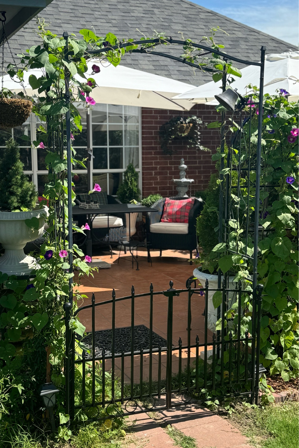 Courtyard patio iron arch with gate
White patio umbrella 
Rot iron furniture
Garden French Patio

#LTKhome