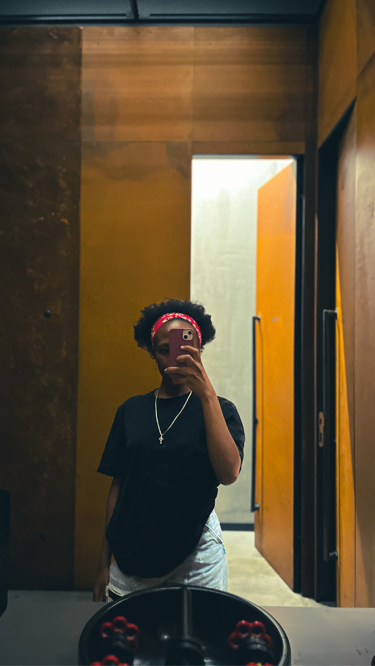  Streetwear 
Wearing an oversized black cotton t-shirt with light blue flare bottom denim jeans. 
Accessories are a cross chain pendant necklace, silver earrings and a pink headband 

#LTKstyletip #LTKeurope