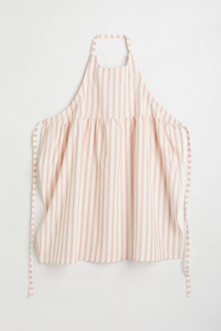 Apron in a woven linen and cotton blend. Neck strap, a gathered seam, and ties at waist. | H&M (US + CA)
