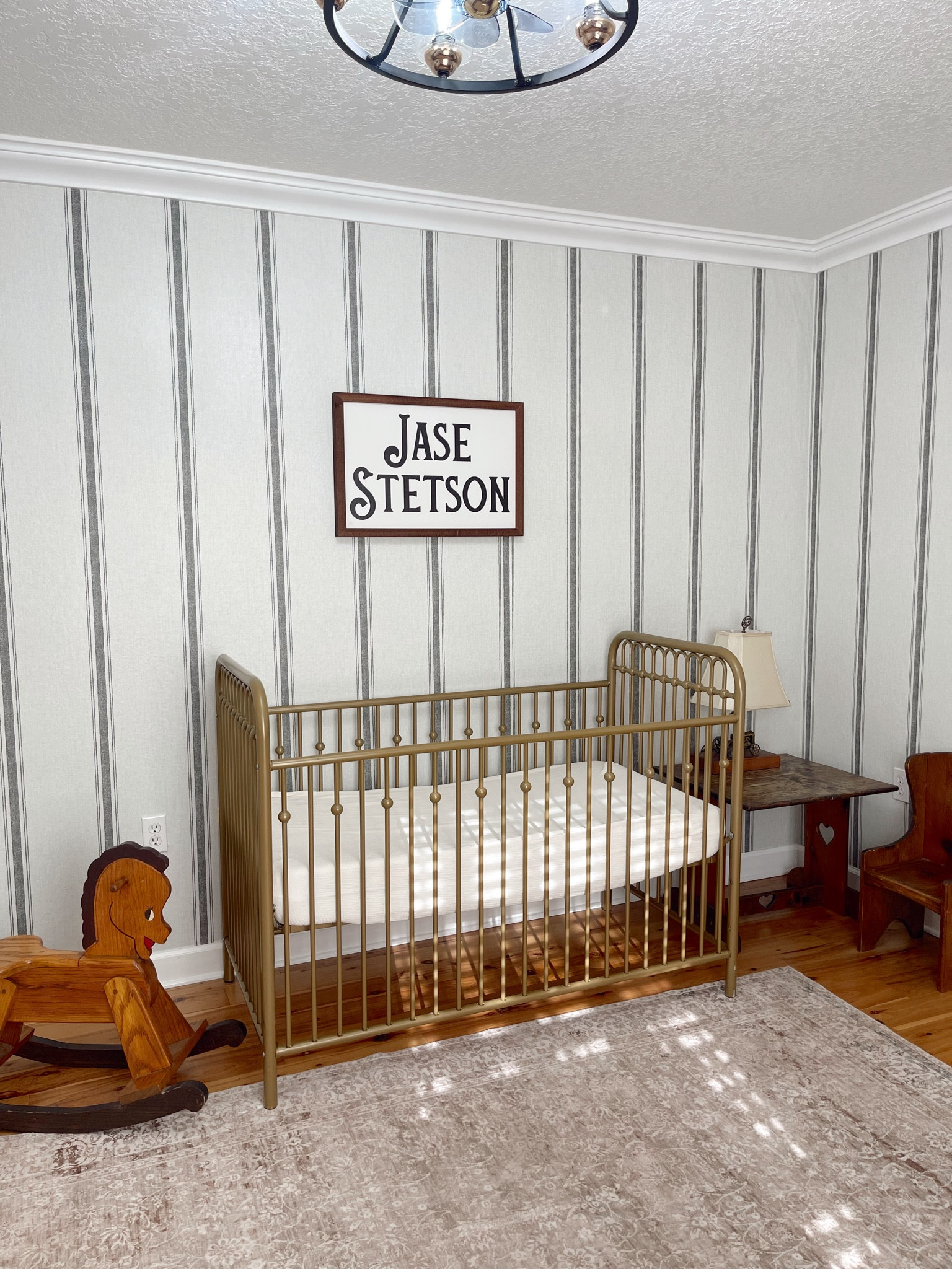 Antique western baby nursery! Peel and stick striped wallpaper was so easy to apply, damage free, and an affordable option available on Amazon. The large cream and tan area rug is also from Amazon and so soft! His name sign is from Smallwood homes. The antique wooden rocking horse and kid’s play table are both family heirlooms but I linked similar options! His vintage Vstyle gold brass crib is a budget friendly find from Amazon and in it is his breathable crib mattress from Newton with breathable cream colored muslin sheets from Amazon for safe sleep. 

#LTKBaby #LTKHome #LTKKids