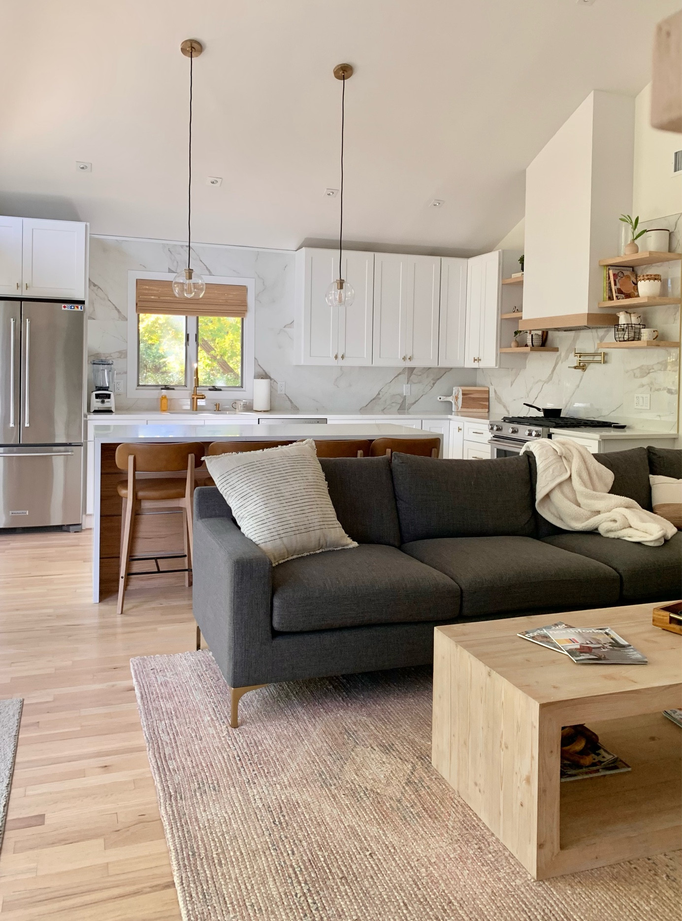 Relaxed living. 

Open concept
Living room
Kitchen
Sectional couch
Wood coffee table
Counter stools
Island
Woven blinds shades
Gold black hardware
Shelf styling
Oven hood
Home decor

#LTKunder100 #LTKhome #LTKfamily