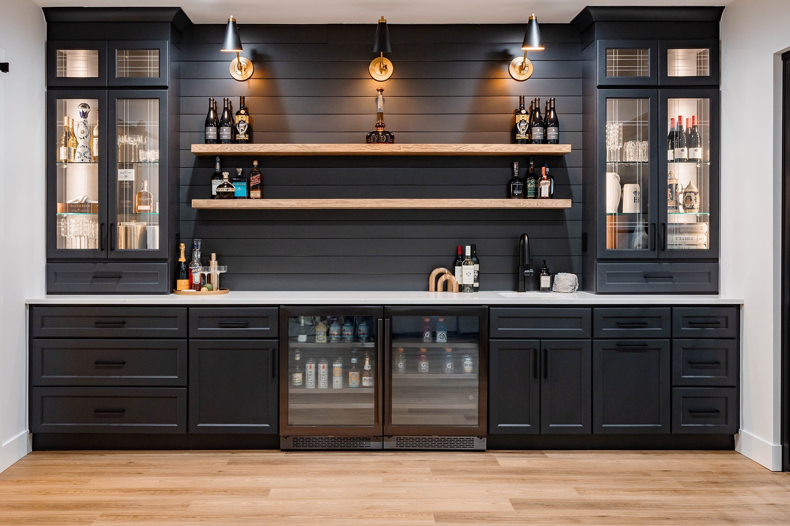 A basement bar for the ages ✨ This 13’ wet bar has EVERYTHING: Dueling beverage centers (one of adults and one for kids), storage, custom shiplap and shelving, stacked glass feature cabinets, bar sink, quartz countertops, pull out trash, and sconce lighting to illuminate the wines and bourbons displayed. This was a fun one to design!

#LTKstyletip #LTKparties #LTKhome
