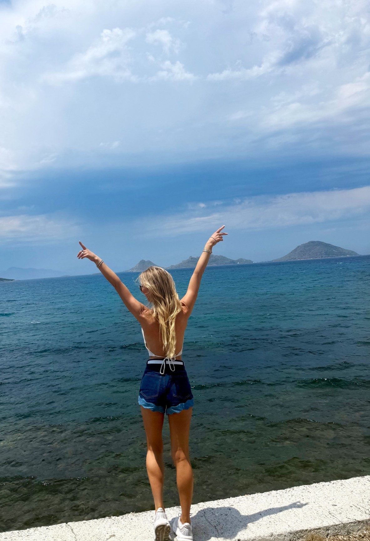 Summer vacation sightseeing outfit! Denim shorts ruffle hem white halter cowl neck backless top 
The most comfortable shoes for walking and sightseeing!

#LTKTravel #LTKActive #LTKootd