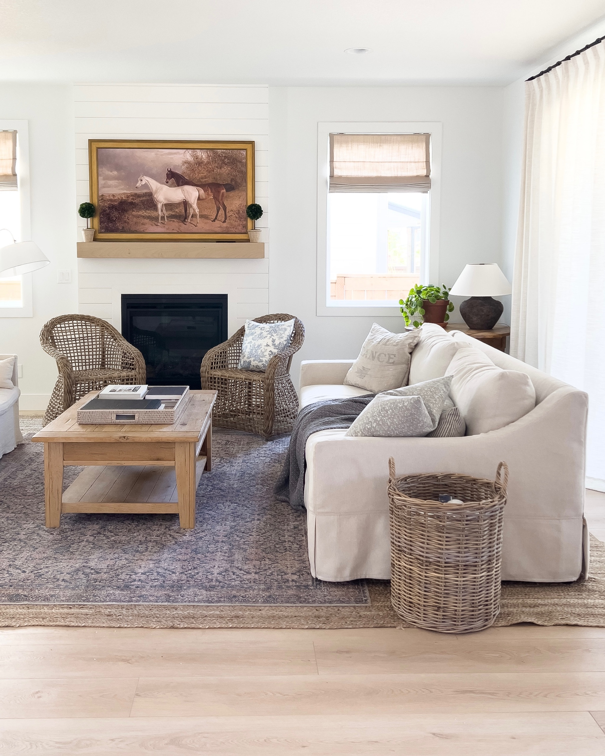 Living room decor, pottery barn slope slip covered sofa, white couch, slope arm couch, performance fabric, family friendly sofa, jute rug, Loloi navy rug, neutral home decor, rattan chair, accent chair, wicker storage basket, transitional home decor, modern traditional home, coastal, Homebyjulianne 

#LTKSeasonal #LTKhome #LTKsalealert